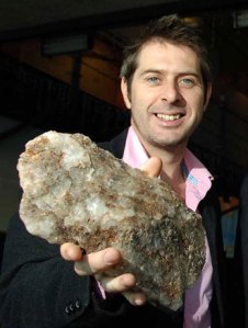 Dr Iain Stewart holding a rock